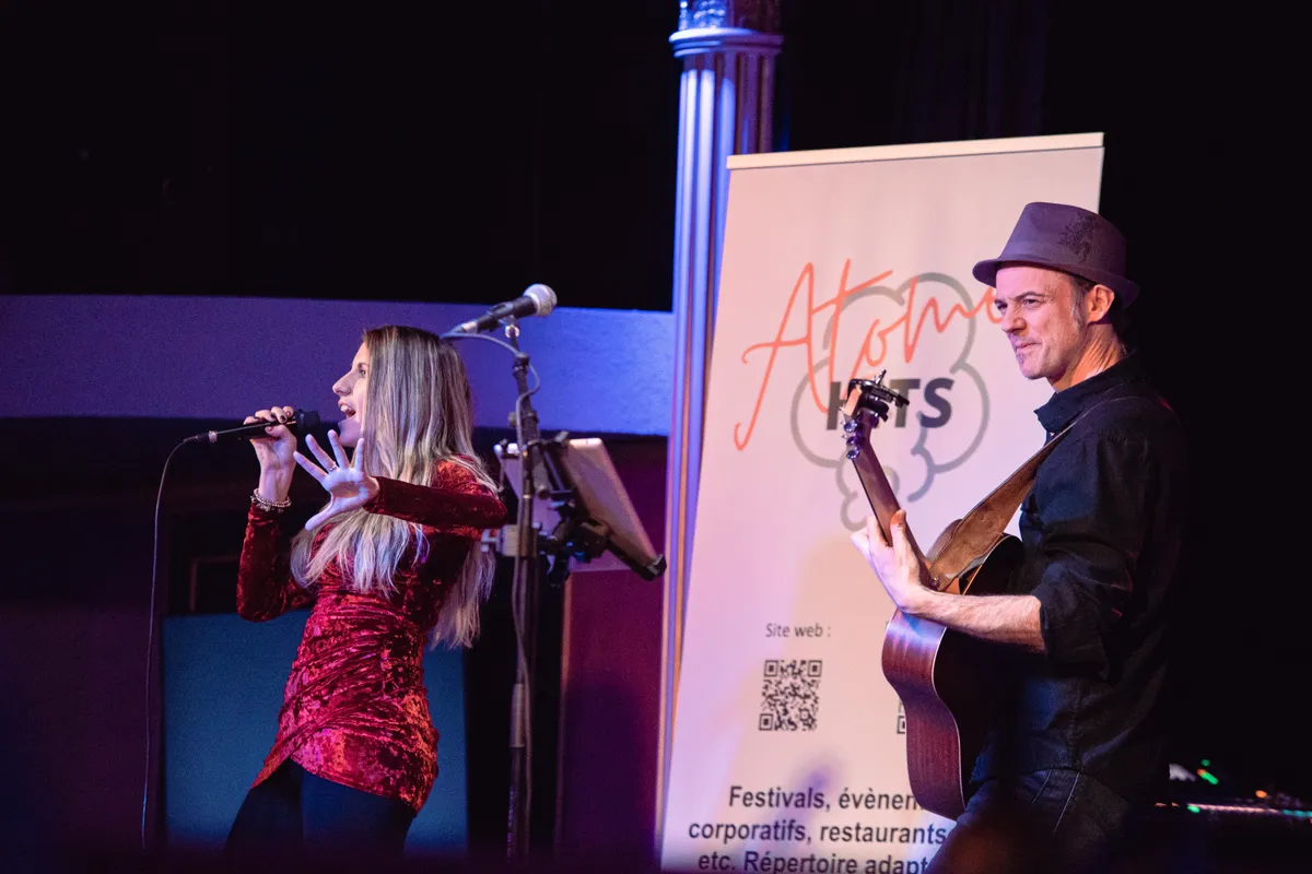 Atome Hits Duo sur scène devant la bannière du duo