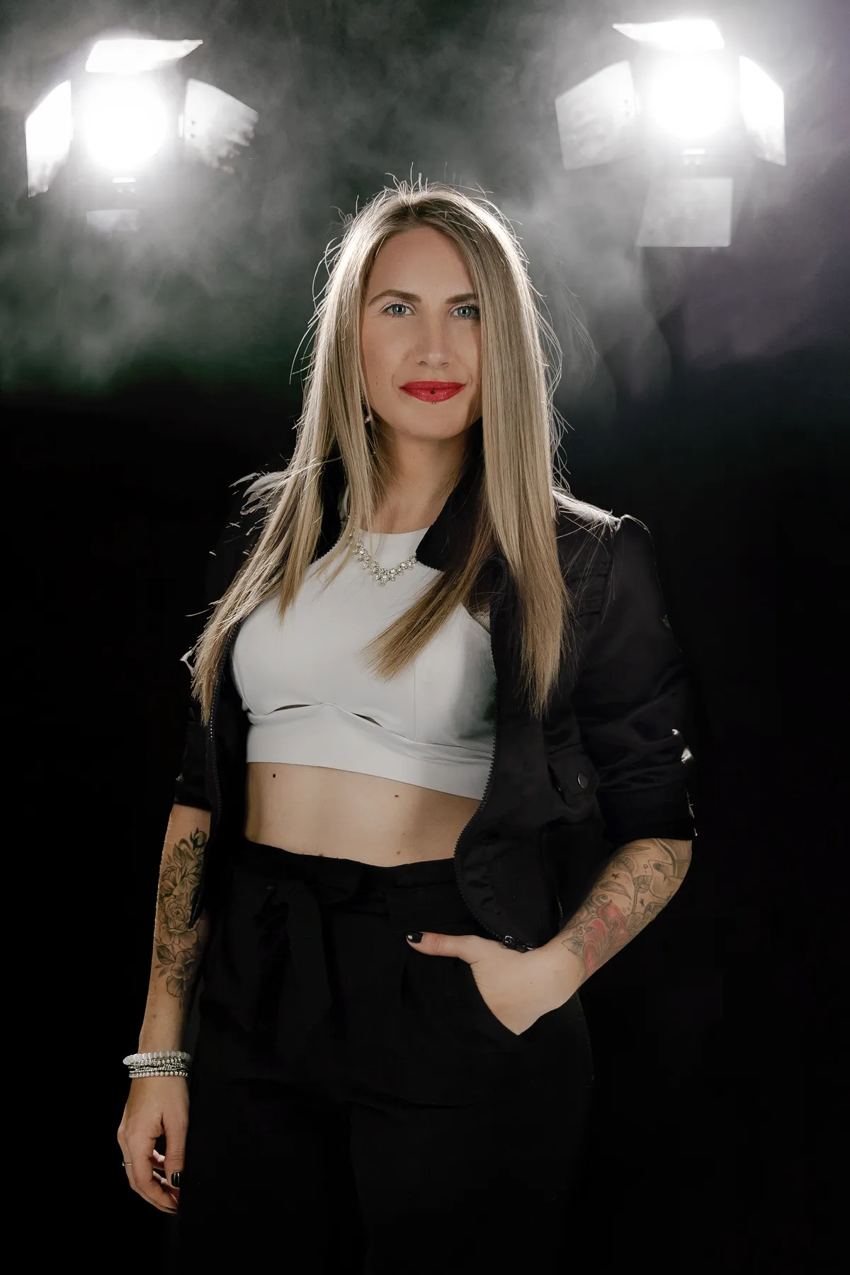 Vanessa Poulin en portrait, micro à la main, sur fond sombre éclairé