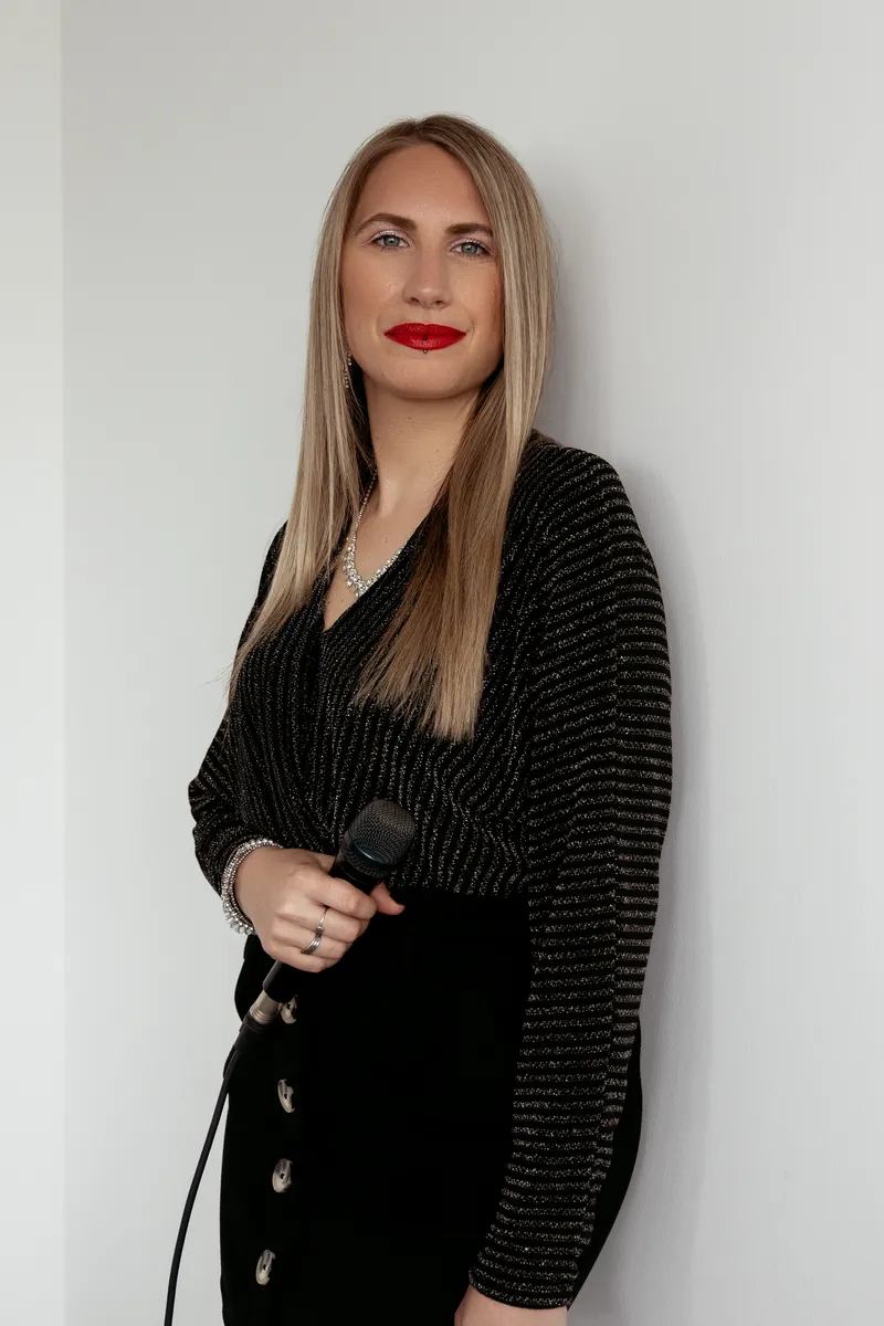 Vanessa Poulin en pied, micro sur pied, sur fond clair