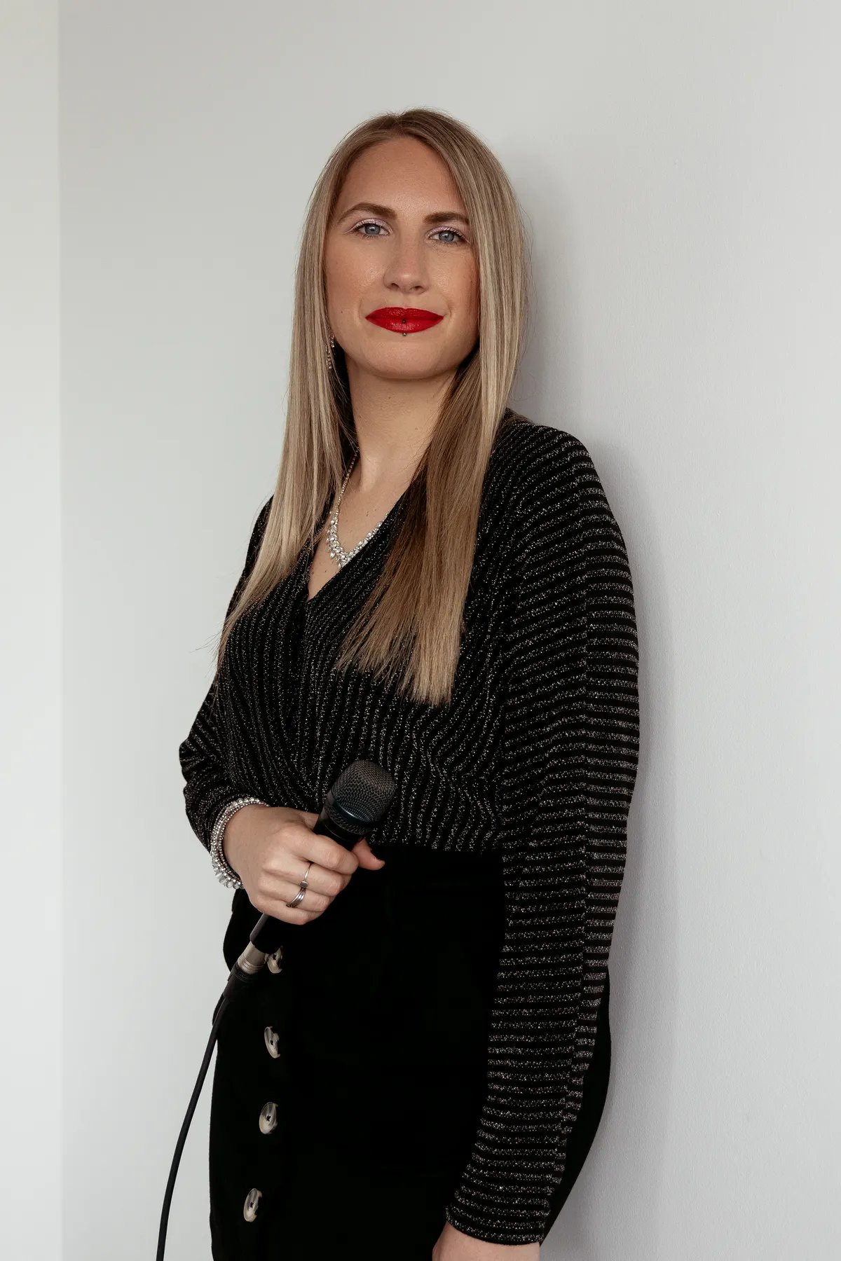 Vanessa Poulin en pied, micro sur pied, sur fond clair